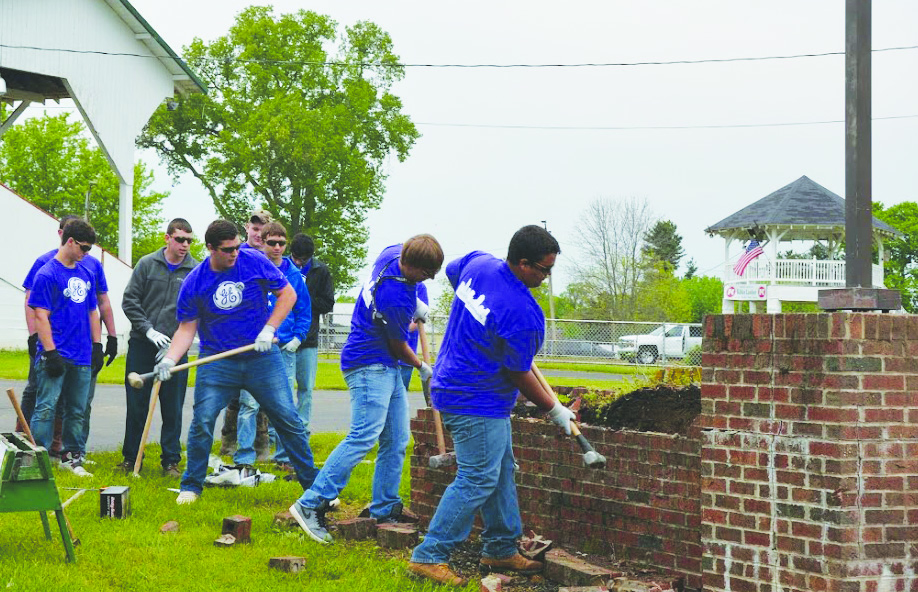 Students working at the Adams County Fairgrounds help demolish a brick structure as part of their Community Day work.