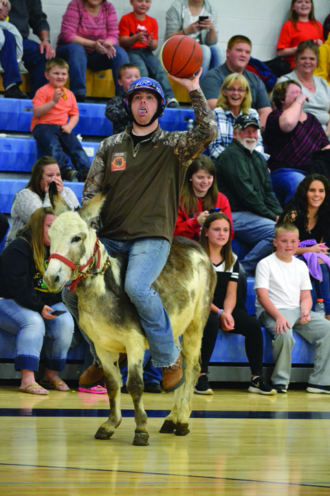 Michael Mills from the Adams County Sheriff’s Department team gets off a one-handed shot attempt during the Donkey Basketball event last weekend at Manchester High School.