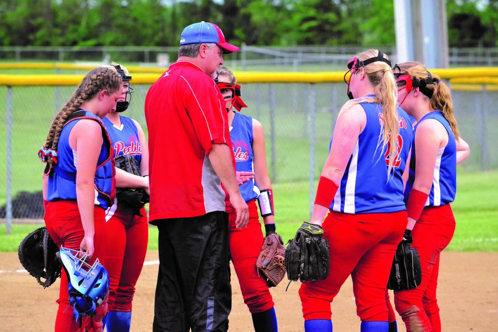 Peebles head coach Doug McFarland meets with his infield during a crucial moment late in the Lady Indians’ 8-5 win over Portsmouth Notre Dame on May 12, a win that gave the Peebles girls a sectional title and a trip to the distrcit tournament. Photo by Mark Carpenter.