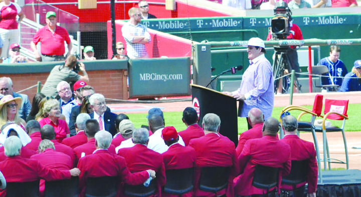 Surrounded by members of the Cincinnati Reds Hall of Fame and other team dignitaries, Pete Rose, right, gives his induction speech as he became the newest member of the Reds HOF during pre-game ceremonies on Saturday, June 25.