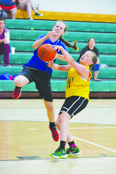 North Adams eighth grader Braylie Jones, right, makes the play on defense, thwarting this Northwest drive to the basket, during action from the June 8 shootout.