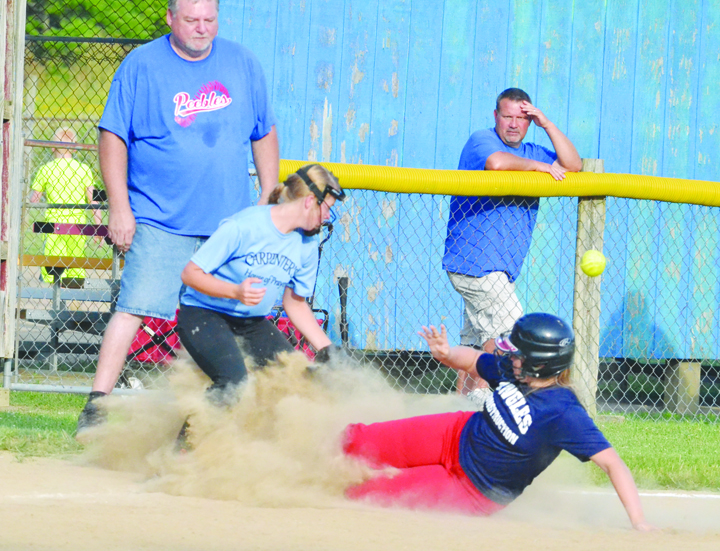Peebles’ Hope Brown slides safely into third base as the ball eludes the Manchester third baseman in action from last week’s semi-final softball tournament game in Hillsboro, won by the Lady Indians 6-0.