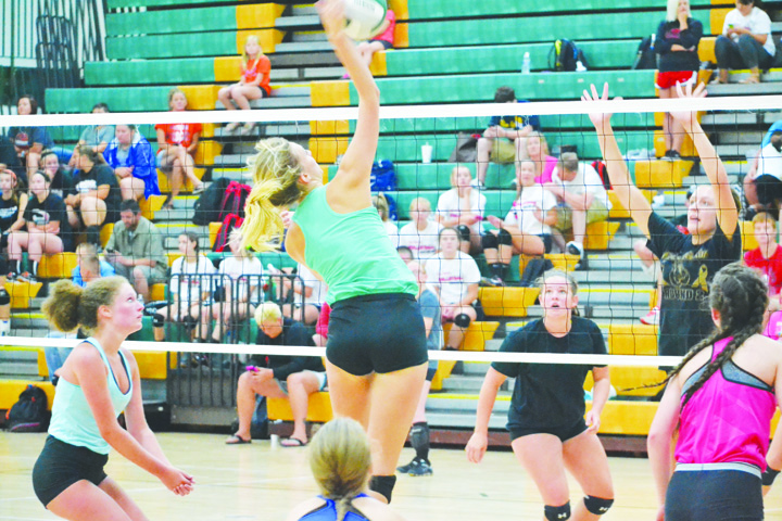 North Adams’ Madison Jenkins, with teammates on all sides, goes up for the kill in action from the July 7 tournament held at North Adams High School.