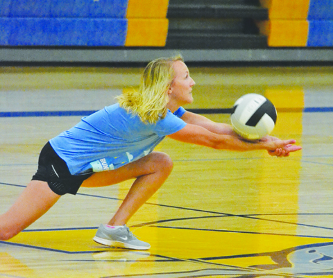 Truly hands-on coaching as new MHS volleyball coach Kaci Compton digs one out while participating in a drill at a volleyball practice last week.