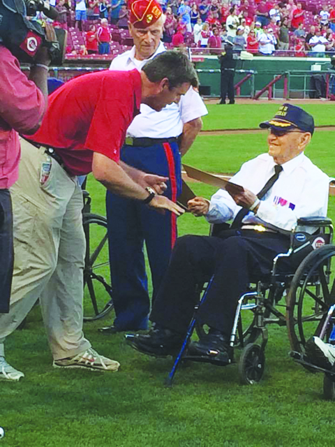 World War II veteran and 96-year old Tom Hughes is awarded a Hometown Hero Certificate for his service by Cincinnati Reds CEO Phil Castellini