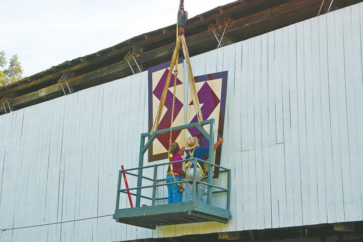 Allen Miller and his son, Marcus, placing the quilt square on Kirker Covered Bridge
