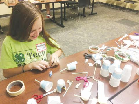 4-H Tech Wizards Madison Bayless, Winchester, engineers a harvester to be powered by Hex Bugs at the Scioto County Ag Bot Challenge Maker station.