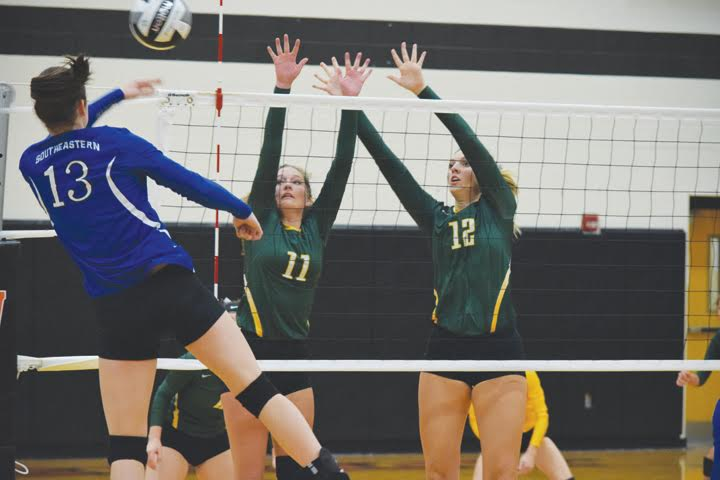 North Adams’ Abby Campton (11) and Madison Jenkins (12) go over the net to try and block this return from Southeastern’s Ella Skeens during the Oct. 25 Division III district semi-final match in Waverly.