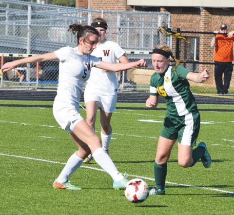 North Adams’ Haley Robinson, right, battles a Wheelersburg opponent for possession during action from last Saturday’s district championship game in Waverly.