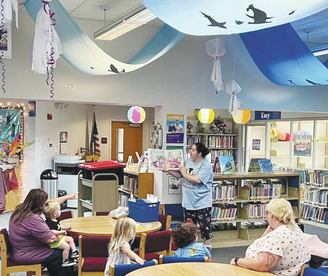 Preschoolers and families can enjoy Storytime at the Adams County Public Libraries all year long. This picture presents the Peebles Library Programmer Sabrena reading The Mermaid by Jan Brett during Storytime.